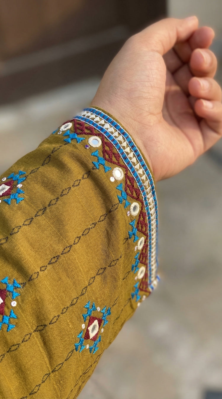 Close-up of Balochi hand embroidered sleeve with tanka work and mirror details
